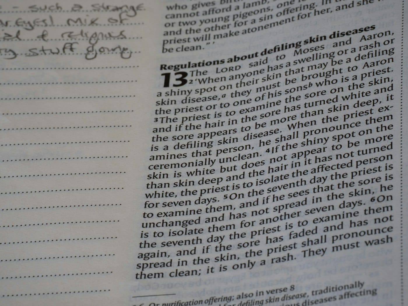 Close-up of open book with text and handwritten notes