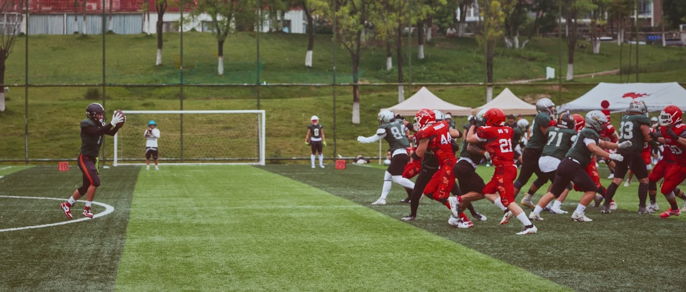 A football player catching a ball on a green field during a game