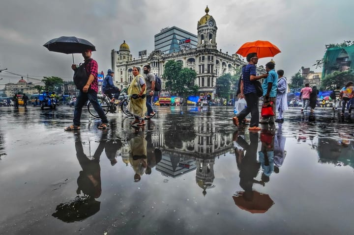 a group of people walking down a street holding umbrellas